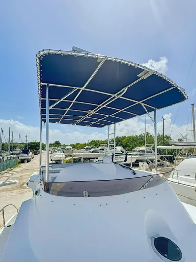 Knot Stupid Yacht Photos Pics 2005 Fountaine Pajot HIGHLAND yacht with blue canopy, docked under clear sky.