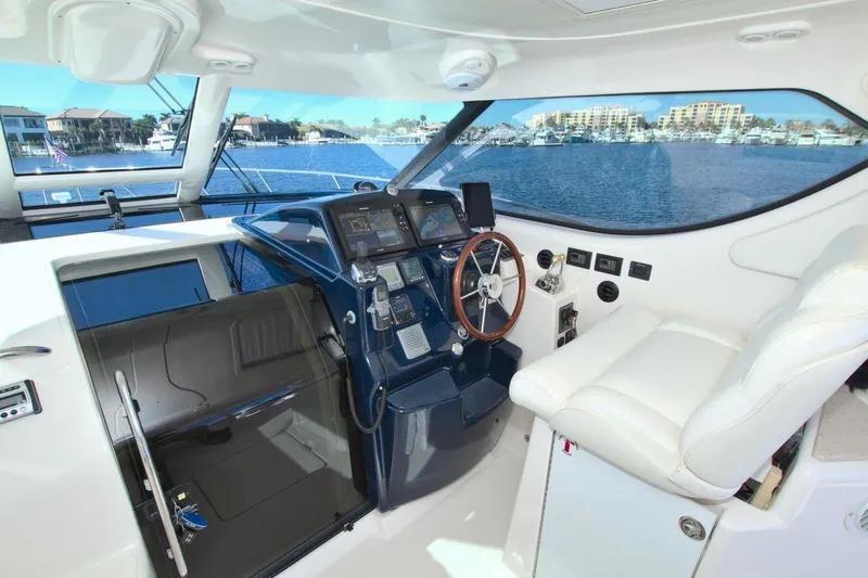 The Adventure Yacht Photos Pics 2008 Tiara Yachts 4300 Sovran helm with modern controls and waterfront view.