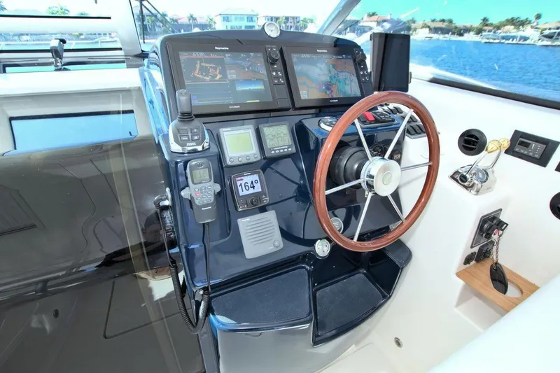 The Adventure Yacht Photos Pics 2008 Tiara Yachts 4300 Sovran helm with navigation equipment and wooden steering wheel.