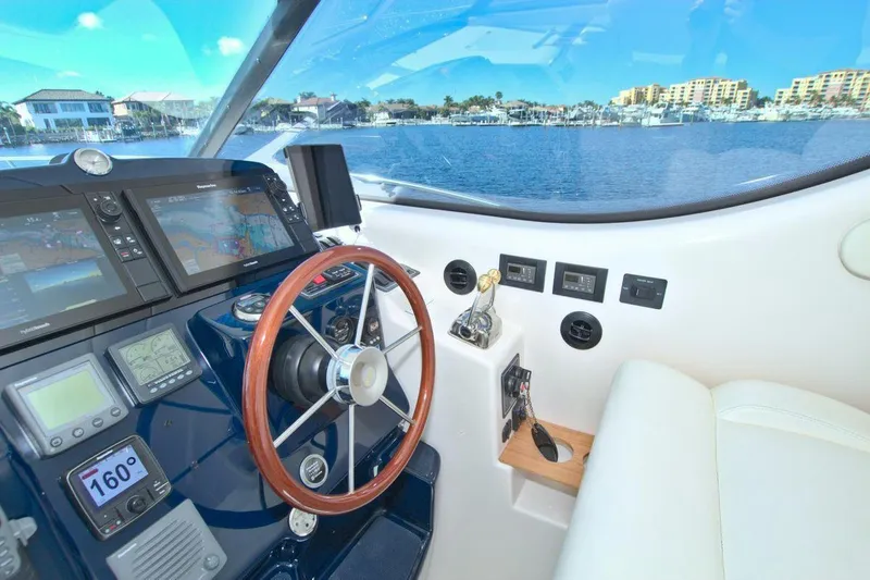 The Adventure Yacht Photos Pics 2008 Tiara Yachts 4300 Sovran helm with navigation displays and wooden steering wheel.