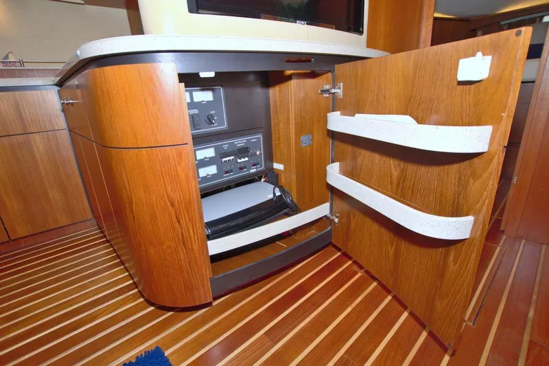 The Adventure Yacht Photos Pics 2008 Tiara Yachts 4300 Sovran interior with open wooden cabinet and control panel.