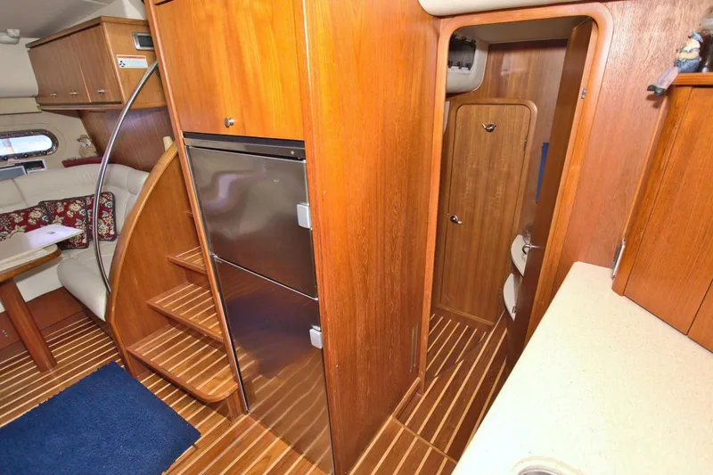 The Adventure Yacht Photos Pics 2008 Tiara Yachts 4300 Sovran interior with wood finish, stairs, and compact kitchen area.