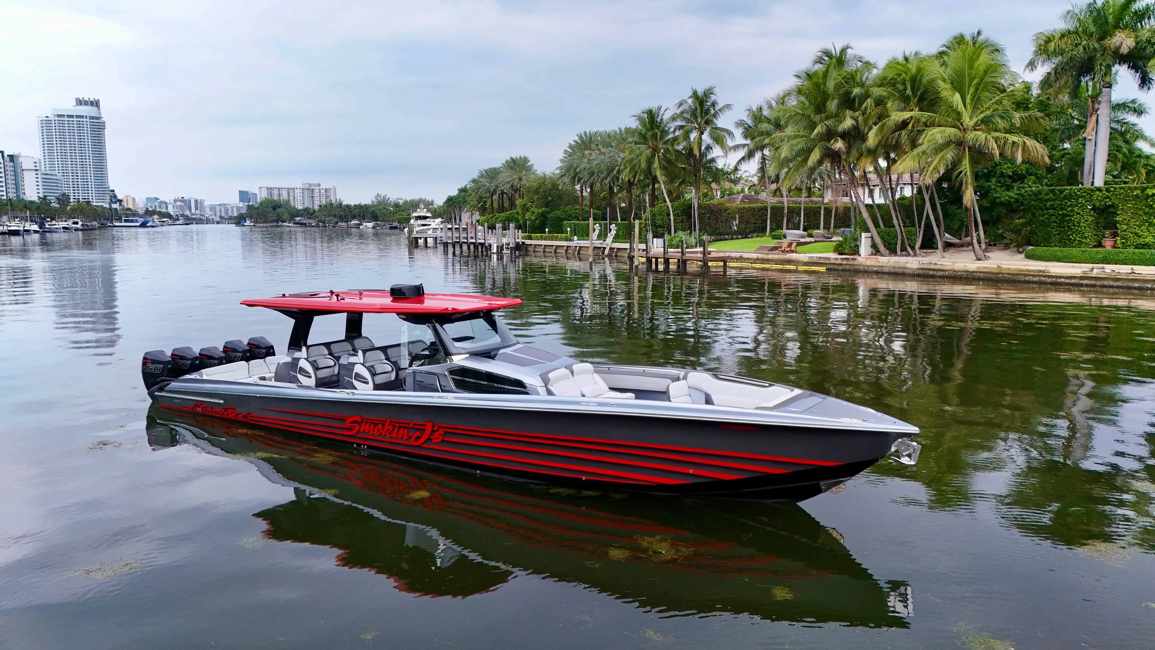  Yacht Photos Pics 2022 Nor-Tech 50 Sport boat on a calm waterway with palm trees and cityscape.