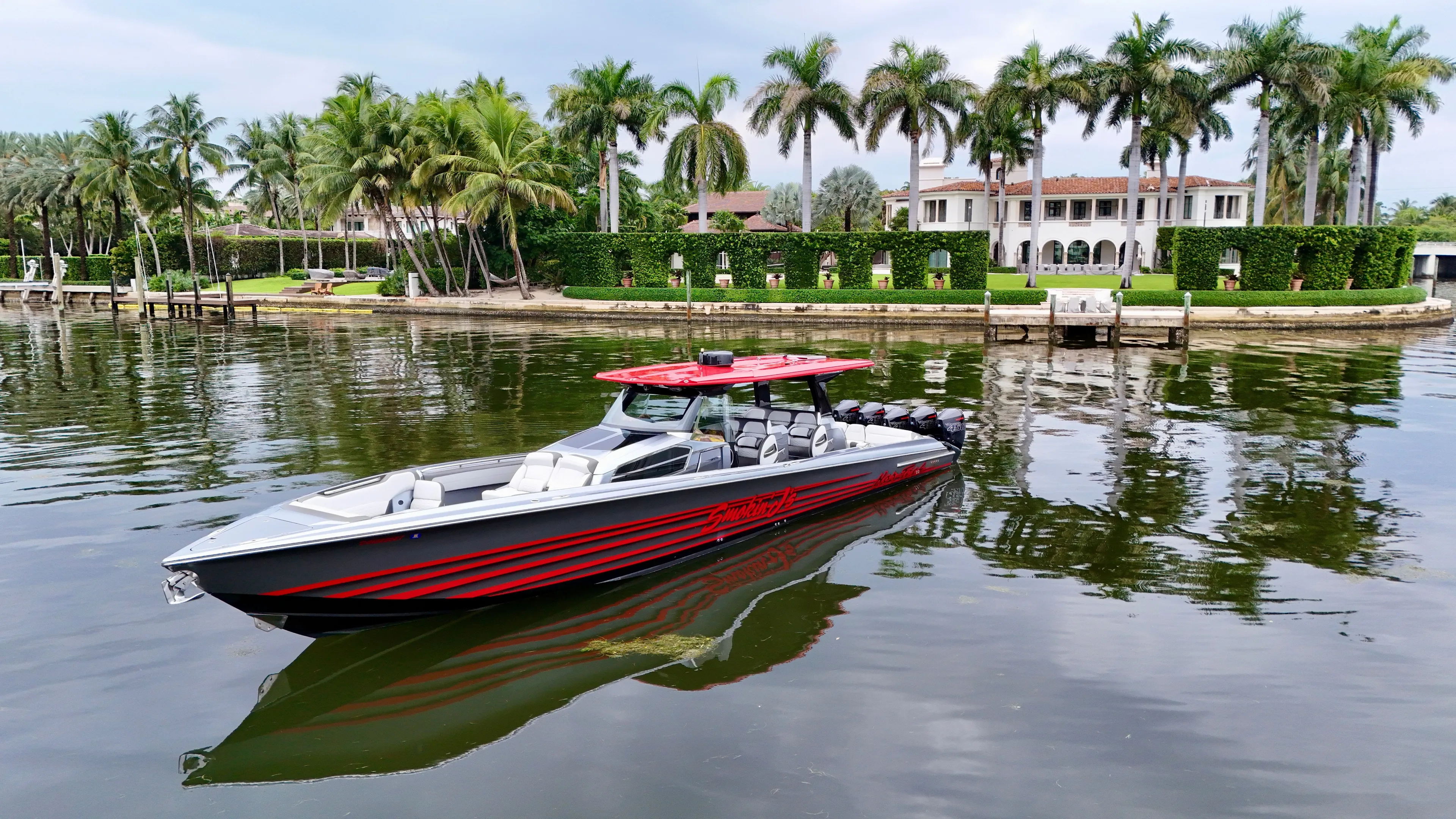  Yacht Photos Pics 2022 Nor-Tech 50 Sport boat on calm water near a luxurious waterfront estate.