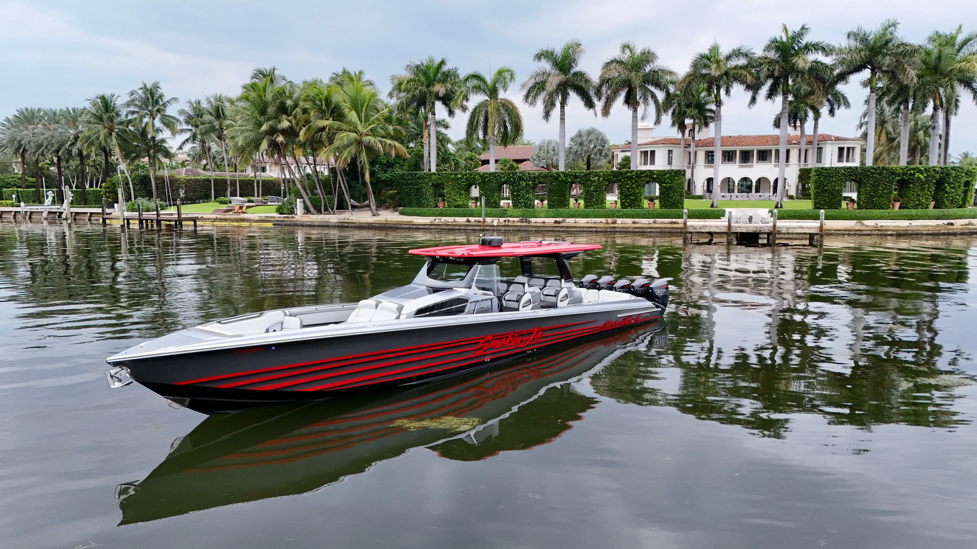  Yacht Photos Pics 2022 Nor-Tech 50 Sport boat on calm water, surrounded by palm trees and luxury estate.