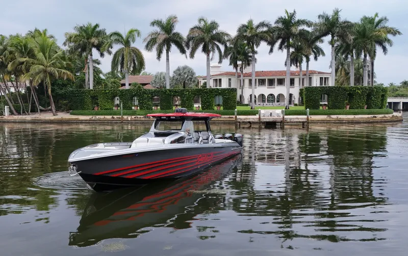  Yacht Photos Pics 2022 Nor-Tech 50 Sport boat cruising near luxury waterfront mansion with palm trees.
