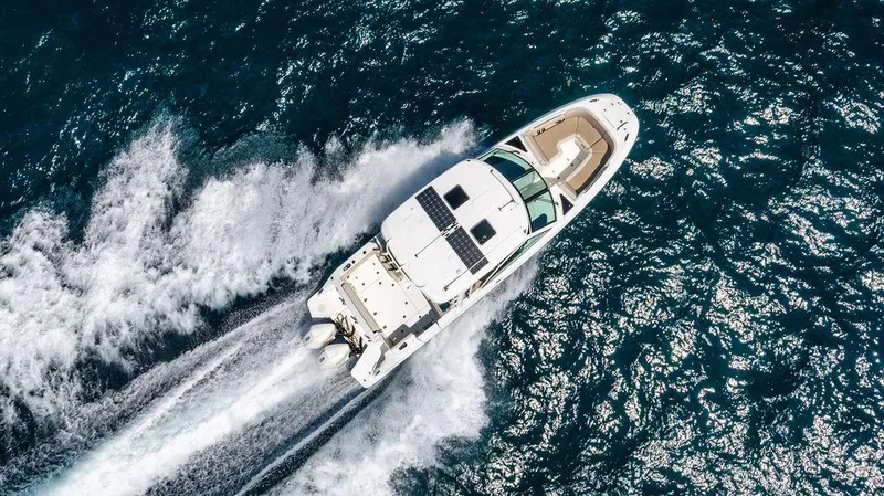  Yacht Photos Pics 2019 Boston Whaler 320 Vantage cruising on open water, aerial view.