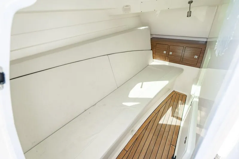  Yacht Photos Pics 2019 Boston Whaler 320 Vantage cabin interior with white seating and wooden flooring.