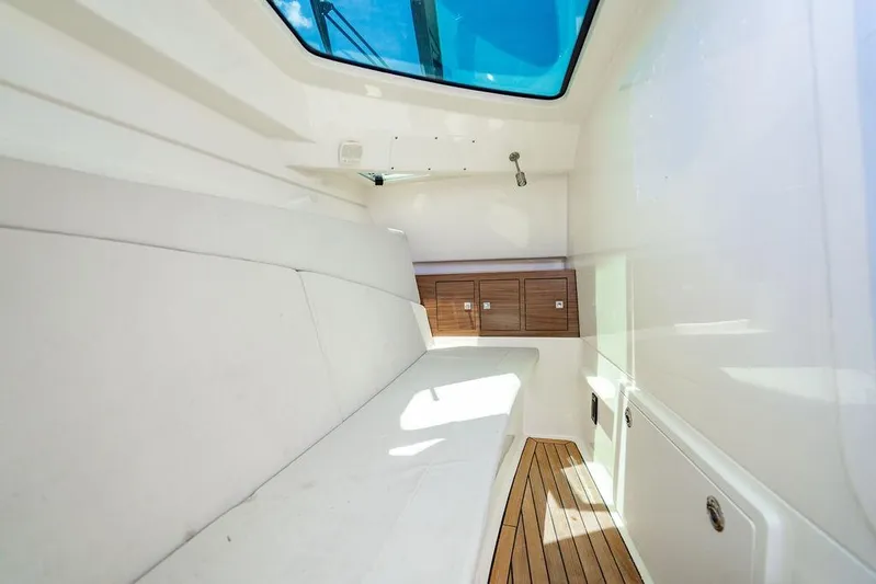 Yacht Photos Pics Interior cabin of 2019 Boston Whaler 320 Vantage with white seating and wooden flooring.
