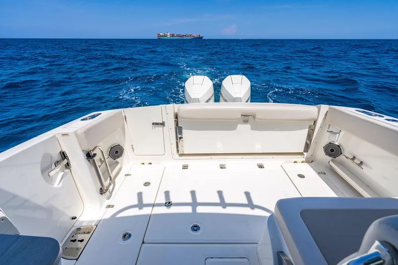  Yacht Photos Pics 2019 Boston Whaler 320 Vantage boat on open sea with distant cargo ship.