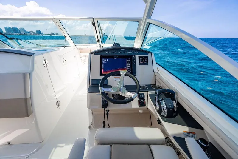  Yacht Photos Pics 2019 Boston Whaler 320 Vantage boat cockpit with steering wheel and navigation system.