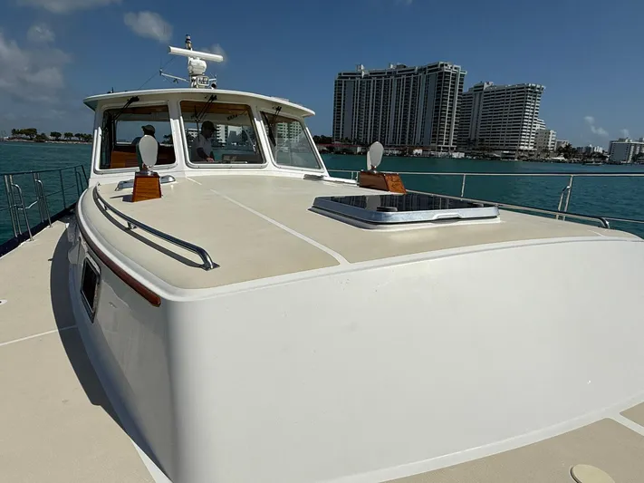 Fiji Yacht Photos Pics 1999 Grand Banks 49 Eastbay HX yacht on water with city skyline in background.