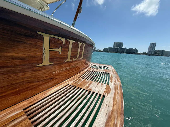 Fiji Yacht Photos Pics 1999 Grand Banks 49 Eastbay HX boat with wooden deck, docked near city skyline.