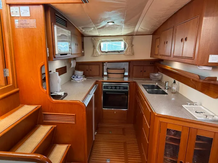 Fiji Yacht Photos Pics 1999 Grand Banks 49 Eastbay HX yacht kitchen with wood cabinetry and modern appliances.