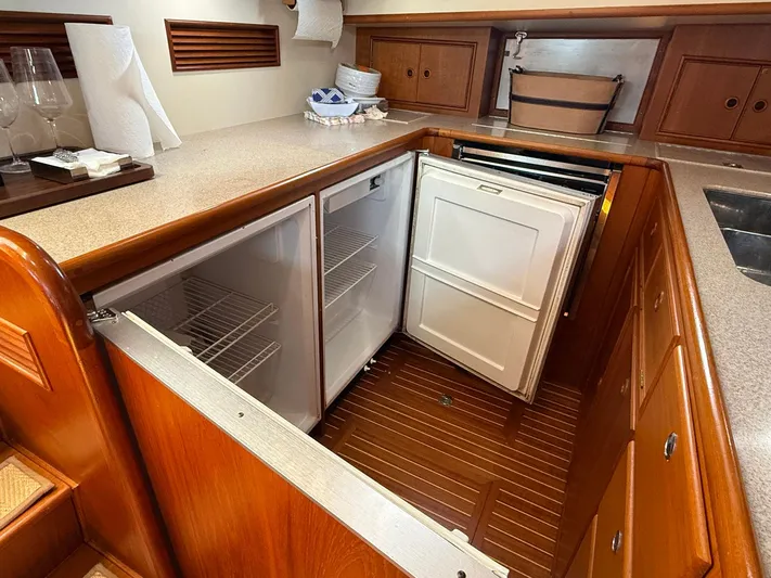 Fiji Yacht Photos Pics 1999 Grand Banks 49 Eastbay HX galley with open refrigerator, wooden cabinetry, and countertop.