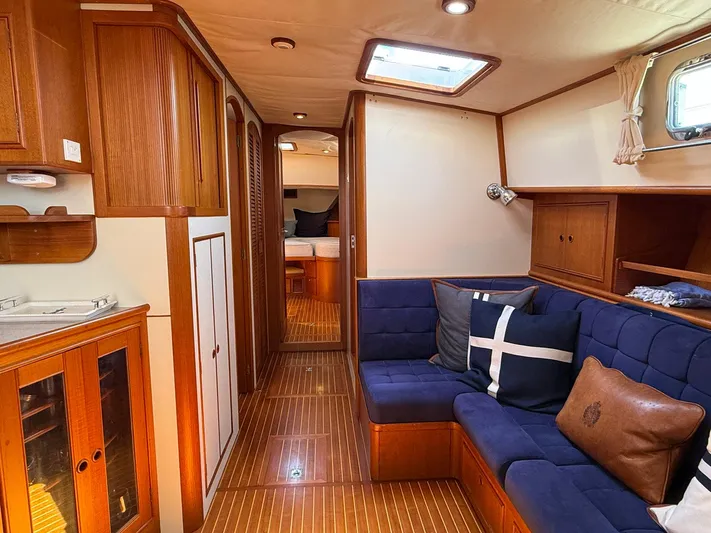 Fiji Yacht Photos Pics Luxurious interior of 1999 Grand Banks 49 Eastbay HX yacht with wood finishes and blue seating.