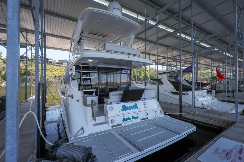Smooth Yacht Photos Pics 2018 Sea Ray Fly 460 yacht docked in a marina under a covered structure.