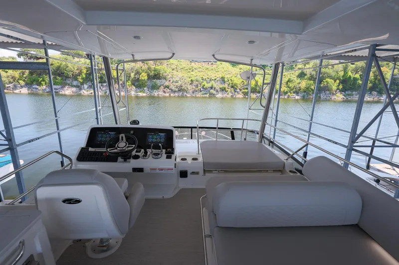 Smooth Yacht Photos Pics Flybridge of 2018 Sea Ray Fly 460 yacht with helm station and seating, overlooking serene water.