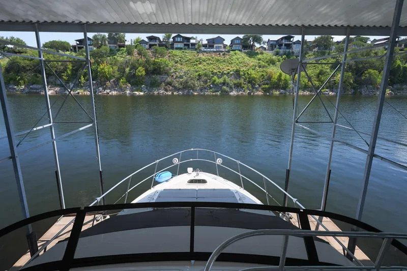 Smooth Yacht Photos Pics 2018 Sea Ray Fly 460 yacht docked, overlooking serene water and lush green shoreline.
