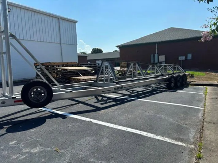 Big Sexy Yacht Photos Pics Trailer parked in a lot, Prowler 42 model, 2020, with metal frame and multiple axles.