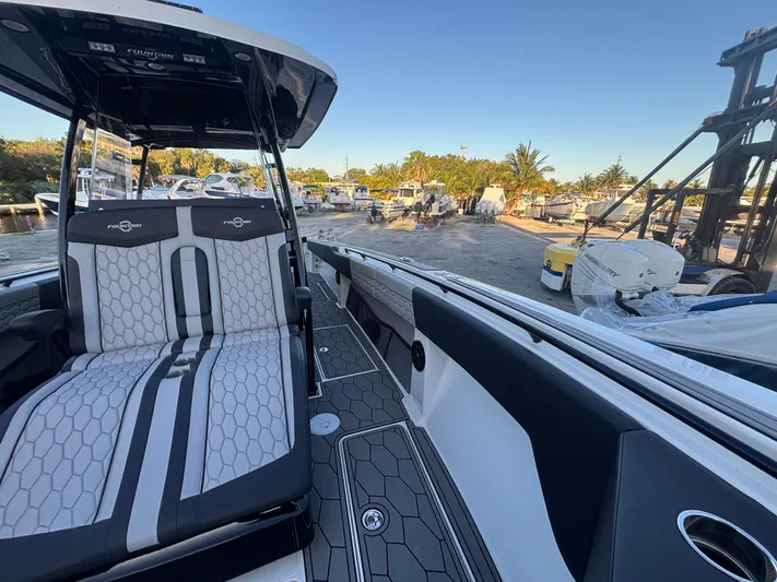  Yacht Photos Pics 2022 Fountain 38 SC boat interior with stylish seating and modern design at a marina.
