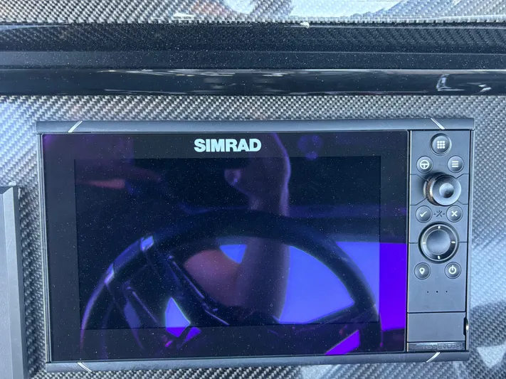  Yacht Photos Pics Simrad display on 2022 Fountain 38 SC boat dashboard, featuring carbon fiber finish.