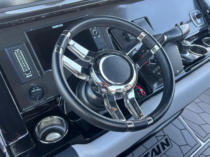  Yacht Photos Pics Steering wheel of a 2022 Fountain 38 SC boat with modern dashboard controls.