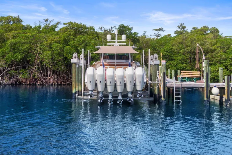 Big Momma Yacht Photos Pics 2023 HCB 65 Estrella docked with multiple outboard engines, surrounded by lush greenery.