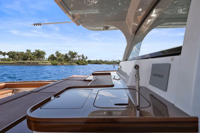 Big Momma Yacht Photos Pics 2023 HCB 65 Estrella yacht deck with Garmin equipment, overlooking tropical waters and palm trees.