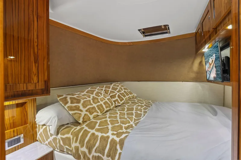 Big Momma Yacht Photos Pics Luxurious cabin interior of 2023 HCB 65 Estrella yacht with cozy bedding and wood accents.