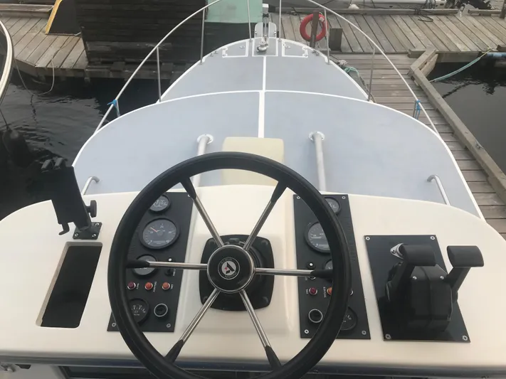 Morning Star V Yacht Photos Pics 1997 Albin 31 Tournament boat helm with steering wheel and control panel at dock.