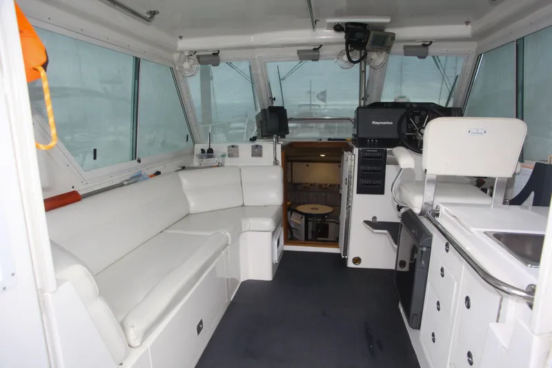 Morning Star V Yacht Photos Pics Interior of a 1997 Albin 31 Tournament boat with white seating and navigation equipment.