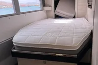 Interior of 2018 Leopard 45 yacht with a neatly made bed and scenic window view.