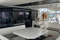 Spacious 2018 Leopard 45 yacht interior with modern seating and helm, docked at marina.