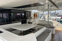 Spacious deck of a 2018 Leopard 45 catamaran with seating and table.