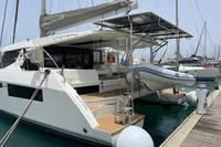 2018 Leopard 45 catamaran docked, featuring solar panels and an attached dinghy.