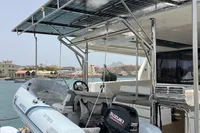 2018 Leopard 45 yacht with solar panels and dinghy in a scenic harbor.