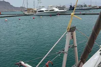 Sailboat docked in marina with mountains in background, Leopard 45 model, 2018.