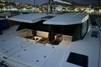 2018 Leopard 45 catamaran at night, docked in a marina with city lights.