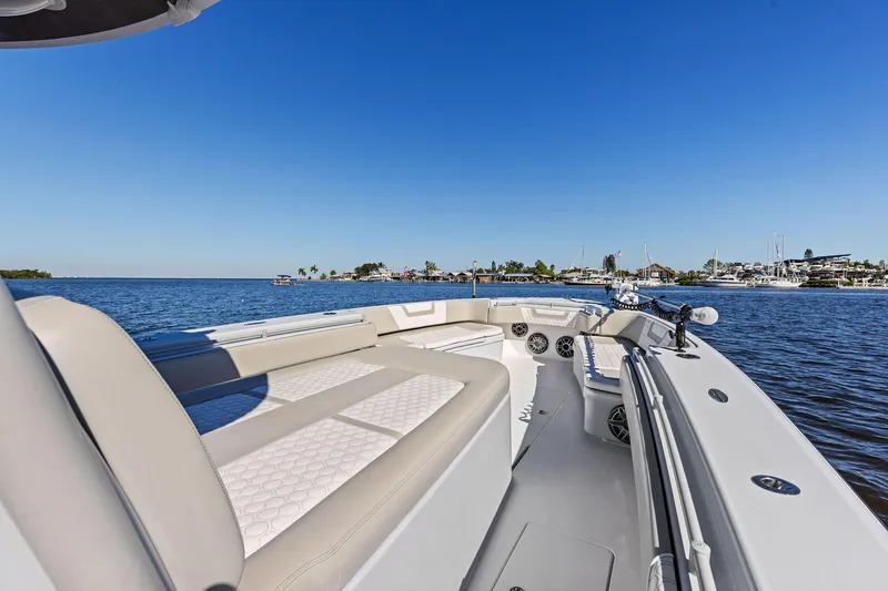  Yacht Photos Pics 2022 Contender 44 CB boat on calm water, featuring spacious seating and clear blue sky.