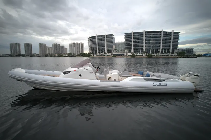 Yacht Photos Pics 2014 SACS Strider 13 boat on calm water with cityscape background.