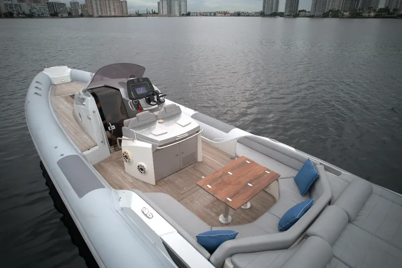 Yacht Photos Pics 2014 SACS Strider 13 luxury boat with seating area and navigation console on calm water.