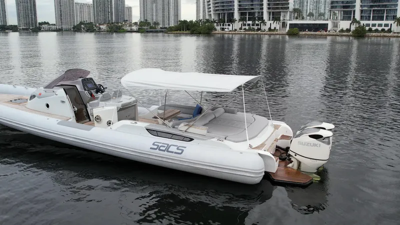  Yacht Photos Pics 2014 SACS Strider 13 boat docked on calm water with cityscape background.
