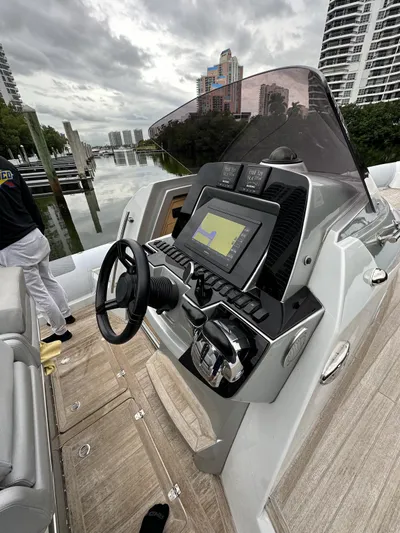  Yacht Photos Pics 2014 SACS Strider 13 boat dashboard with navigation system, docked near high-rise buildings.
