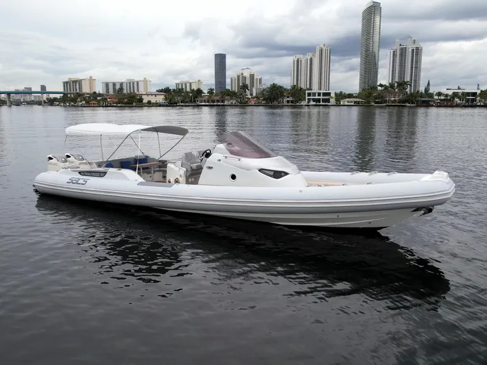  Yacht Photos Pics 2014 SACS Strider 13 boat on calm water with city skyline background.