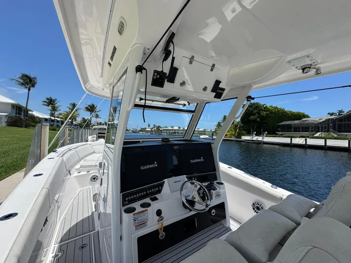  Yacht Photos Pics 2023 Sea Fox 368 Commander boat interior with Garmin navigation, docked by a canal.