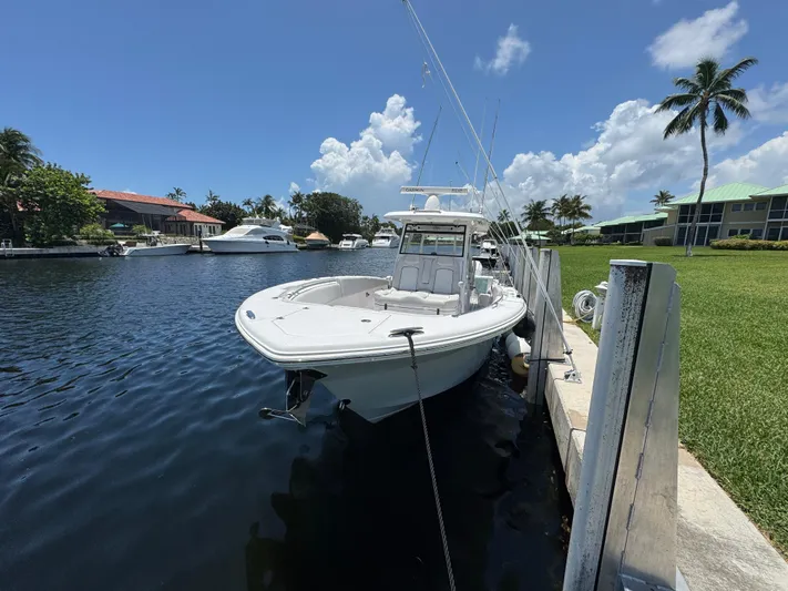  Yacht Photos Pics 2023 Sea Fox 368 Commander docked by a scenic waterfront with palm trees.