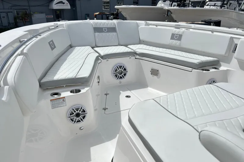  Yacht Photos Pics Luxurious seating area on 2026 Sea Fox 328 Commander boat, featuring white cushioned seats and speakers.