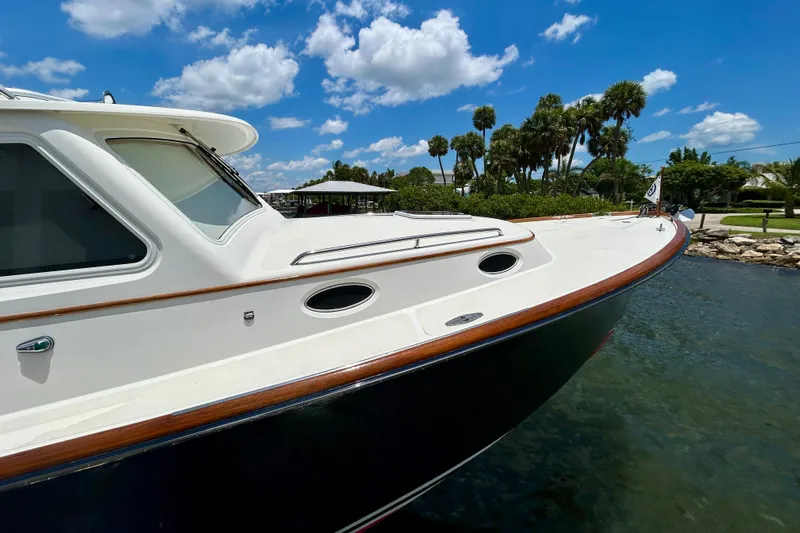 Clarity Yacht Photos Pics 2006 Hinckley 36 EP Picnic Boat on water, clear sky, palm trees in background.