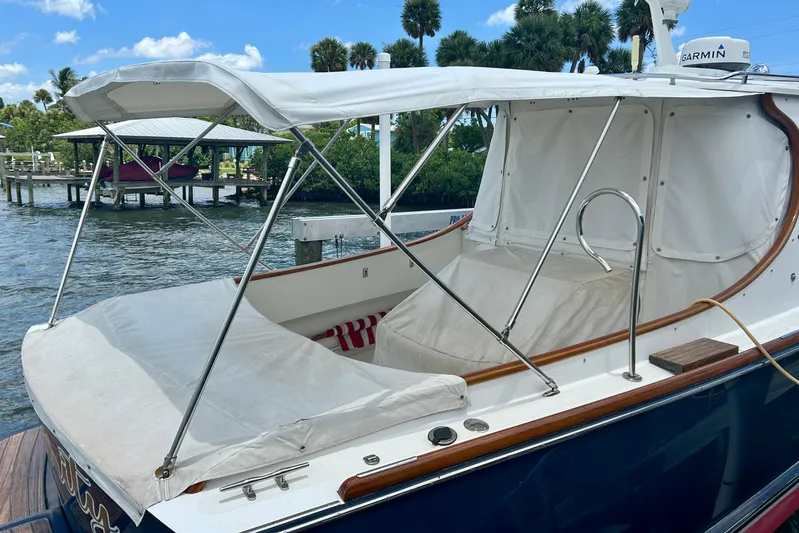 Clarity Yacht Photos Pics 2006 Hinckley 36 EP Picnic Boat with canopy, docked by water, under clear blue sky.